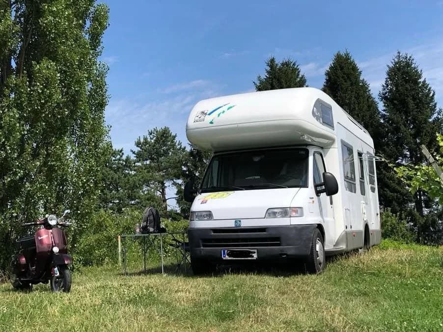 Person standing beside a caravan at the campsite